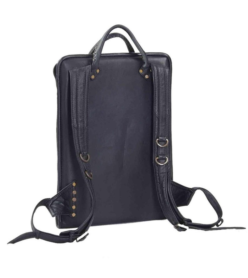 May include: Black leather backpack with adjustable straps and metal hardware. The backpack has a flap closure and a zipped pocket on the front.