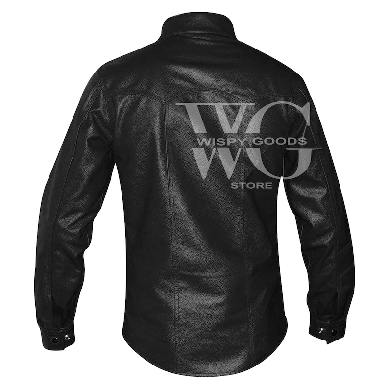 Back view of the long-sleeved black leather shirt. It highlights a curved western-style yoke across the upper shoulders with double-stitched vertical seams running down to the slightly curved hem. The cuffs on the long sleeves are finished with a single visible snap button closure. The entire garment shows a uniform pebble-grained texture.