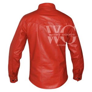 Back view of the long-sleeved red leather shirt. It highlights a curved western-style yoke across the upper shoulders with double-stitched vertical seams running down to the slightly curved hem. The cuffs on the long sleeves are finished with a single visible snap button closure.