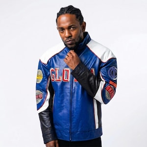 Puede incluir: Chaqueta de cuero azul, blanca y negra con la palabra "GLOBAL" en letras rojas. La chaqueta tiene parches en las mangas y los hombros. La chaqueta tiene un cuello blanco y rayas blancas a los lados.