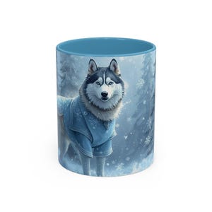 Puede incluir: Taza de cerámica con una ilustración detallada de un perro Husky con un abrigo azul con diseños de copos de nieve. La taza tiene un interior azul claro y un fondo de escena de bosque invernal.