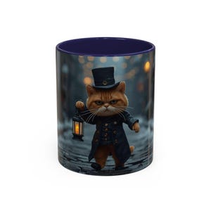 Puede incluir: Taza de cerámica con interior azul marino y una imagen envolvente de un gato jengibre vestido con abrigo negro y sombrero de copa, sosteniendo una linterna. El gato camina por un camino empedrado.