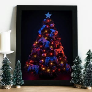 May include: A framed print featuring a Christmas tree adorned with video game controllers and baubles. The tree is illuminated with colourful lights and a blue star. Miniature Christmas trees and a candle are in front of the framed print.