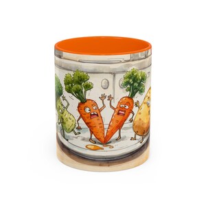 May include: A ceramic mug with an orange interior and a whimsical illustration of anthropomorphic vegetables. The design features cartoon carrots, a cucumber, and a potato with expressive faces, set against a kitchen backdrop.