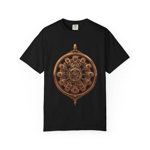Puede incluir: Camiseta negra con un diseño de reloj ornamentado y detallado en tonos dorados y marrones. La esfera del reloj tiene un marco circular con detalles intrincados y un mecanismo de reloj central. El diseño está centrado en la parte delantera de la camiseta.