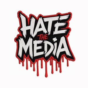 May include: An embroidered patch featuring the text HATE THE MEDIA in a jagged, white, brush-stroke style font. The letters are set against a black background with a thick red border, and red liquid-like drips extend from the bottom edge.