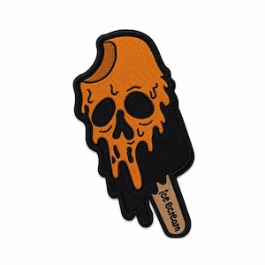 Puede incluir: Un parche bordado con forma de polo derritiéndose con un diseño de calavera. El polo es naranja con detalles en negro, mostrando una cara de calavera con ojos y nariz huecos. El palo de madera es color canela con el texto ice ecream en negro.