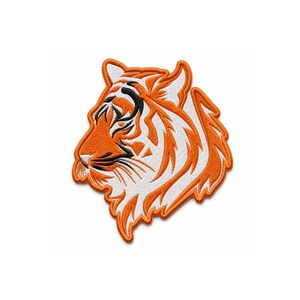 May include: An embroidered patch featuring the profile of a tiger head. The design uses vibrant orange, crisp white, and bold black thread to create the tiger's facial features, including its distinctive striped markings and pointed ears.