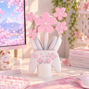 以下が含まれることがあります： 5つのピンクの桜の花で飾られた中央の垂直ポールを備えた、白いゲームコントローラーおよびヘッドフォンスタンド。このスタンドは、ベース部分に白いワイヤレスゲームコントローラーを、上部に白いヘッドフォンを保持するように設計されています。