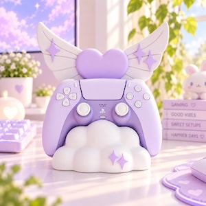 May include: A lavender video game controller resting on a white cloud-shaped stand. The stand features a large lavender heart with white angel wings and small purple star accents. The controller has standard buttons, joysticks, and a PlayStation logo.