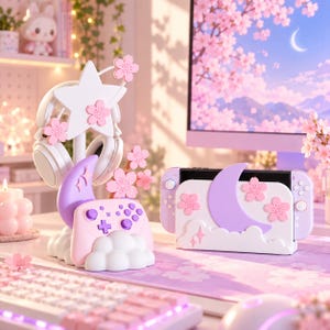 Peut inclure: Un ensemble d'accessoires de jeu blanc et violet pastel comprenant un support de casque avec une étoile et des fleurs de cerisier, une station pour manette en forme de croissant de lune et de nuages, et une station pour console assortie.