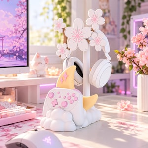 以下が含まれることがあります： 白い桜の花が飾られた中央の支柱を持つ、白とパステルカラーのゲーミングアクセサリースタンド。土台は白い雲と黄色い三日月を模しており、白いゲームコントローラーと白いヘッドフォンを収納できるデザインになっている。