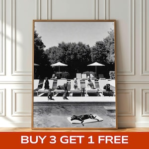 May include: Black and white framed print featuring a group of dogs lounging by a pool. Several dogs are on lounge chairs, while one rests on a floating mat. The image includes umbrellas and trees in the background. Text at the bottom reads "BUY 3 GET 1 FREE".