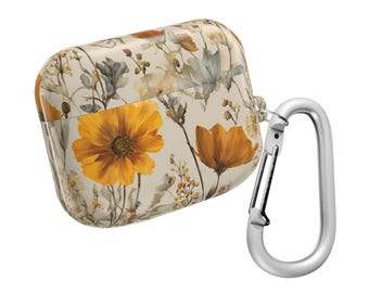 Puede incluir: Una funda beige y blanca con estampado floral para auriculares inalámbricos con un mosquetón plateado.