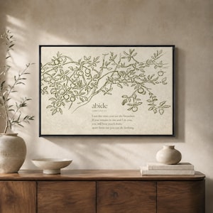 May include: A rectangular wall art piece in a black frame featuring a line drawing of a fruit-bearing vine in olive green on a beige background. The text reads: abide (John 15:1-5) I am the vine; you are the branches. If you remain in me and I in you, you will bear much fruit; apart from me you can do nothing.
