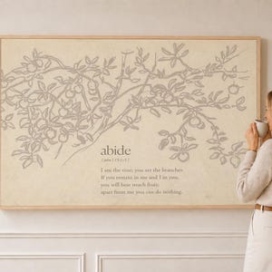 May include: A rectangular wall art print in a light wood frame featuring a line drawing of a fruit-bearing vine in gray on a beige background. The text reads: abide, John 15:5, I am the vine; you are the branches. If you remain in me and I in you, you will bear much fruit; apart from me you can do nothing.