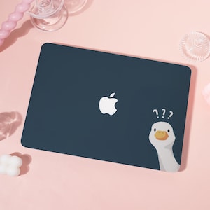 May include: A navy blue laptop case with a white Apple logo and a cartoon goose with question marks. The goose has a white head and a yellow beak, peeking from the side. The case is rectangular.