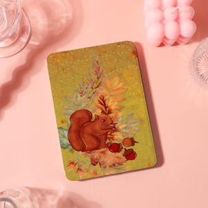May include: A rectangular, olive-green decorative tray featuring a detailed illustration of a brown squirrel with a bushy tail, surrounded by autumn leaves and acorns. The tray has a dotted pattern background.