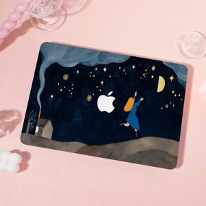 May include: Laptop case featuring a whimsical night sky scene. A woman in a blue dress reaches for the moon and stars. A small house with smoke rising from the chimney is in the background. The Apple logo is prominently displayed.