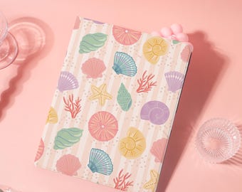 Può includere: Una custodia per tablet con un motivo a conchiglie colorate. Il design include varie conchiglie, stelle marine e coralli in tonalità pastello di rosa, blu, giallo e verde, su uno sfondo a righe.