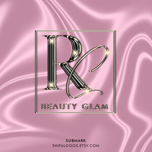 Pode incluir: Uma letra estilizada "R" prateada e preta com contorno dourado e detalhes brilhantes. A letra est&aacute; em um quadro quadrado com o texto "BEAUTY GLAM" abaixo. O fundo &eacute; um tecido de cetim rosa.