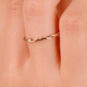 Puede incluir: Un anillo de banda trenzado de color dorado.