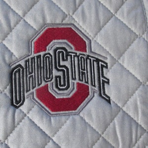 May include: Gray quilted hot pad with the Ohio State logo embroidered in red, black, and gray.
