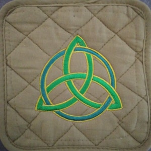 May include: A brown quilted pot holder with an embroidered green and yellow Celtic knot design.