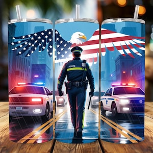 Könnte beinhalten: Ein Edelstahlbecher mit einem patriotischen Design. Das Kunstwerk zeigt einen Polizisten, der eine Stadtstraße entlanggeht, mit amerikanischen Flaggenflügeln und einem Adler. Polizeiautos mit Blaulicht sind ebenfalls zu sehen.