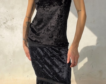 Könnte beinhalten: Ein schwarzes Camisole-Top aus zerknittertem Samt mit einem spitzenbesetzten V-Ausschnitt, kombiniert mit einem passenden schwarzen Midirock aus zerknittertem Samt mit horizontalen Spitzenverzierungen und gestuftem Schnitt.