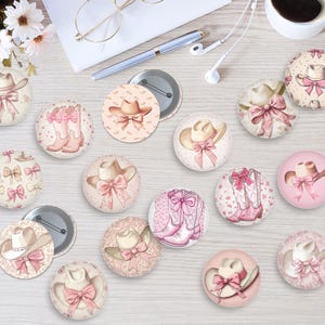 May include: A collection of round, decorative pinback buttons with a country and western theme. The buttons feature illustrations of cowboy hats, bows, and cowboy boots in shades of pink, beige, and white. Some buttons have a floral pattern.