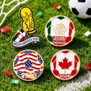 Peut inclure: Quatre épinglettes en émail métallique sur le thème du football. L'une représente une main tenant un trophée avec le texte NORTH AMERICA 2026. Trois épinglettes circulaires montrent des ballons aux couleurs du Mexique, des USA et du Canada, marqués 2026.