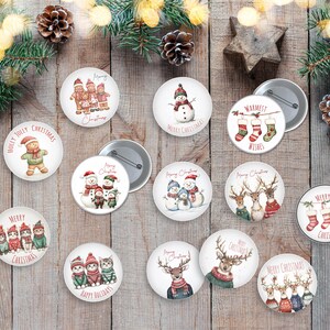 Pode incluir: Uma coleção de botões de Natal com vários designs. Os botões apresentam imagens de bonecos de neve, renas, gatos e bonecos de gengibre, juntamente com textos festivos como "Merry Christmas" e "Happy Holidays". Os botões estão dispostos numa superfície de madeira.