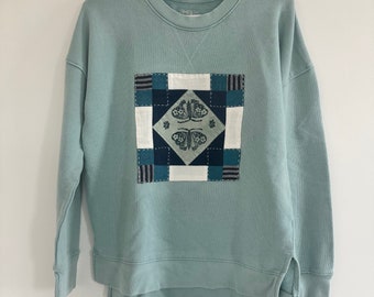 Hand quilted upcycled teal sweatshirt with hand stamped flower