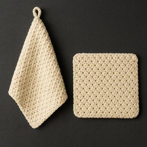 Op de afbeelding: Twee gehaakte theedoeken in beige kleur. Eén is vierkant en de andere is rechthoekig met een lus om op te hangen.