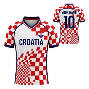 May include: A white and red checkered Croatia soccer jersey with the word "CROATIA" in blue. The jersey has a blue collar and sleeves. The back of the jersey has the number 10 and the text "YOUR NAME".
