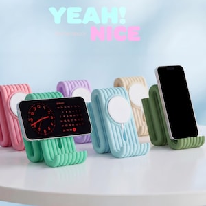 Könnte beinhalten: Eine Sammlung farbenfroher Telefonständer in Pink, Grün, Lila, Beige, Blau und Grün. Jeder Ständer hat ein einzigartiges Design mit einem kreisförmigen Ladepad und einem Schlitz zur Aufnahme eines Telefons. Die Worte "YEAH!" und "NICE" sind im Hintergrund.