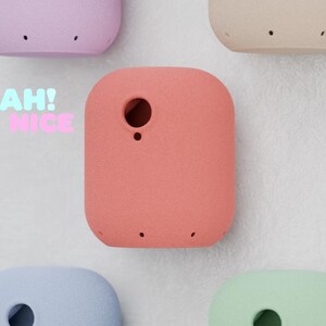 Könnte beinhalten: Eine Sammlung farbenfroher, abgerundeter rechteckiger Objekte in Rosa, Beige, Lila, Blau und Grün. Jedes Objekt hat ein kreisförmiges Loch und kleine Punkte. Die Worte "YEAH! NICE" sind sichtbar.
