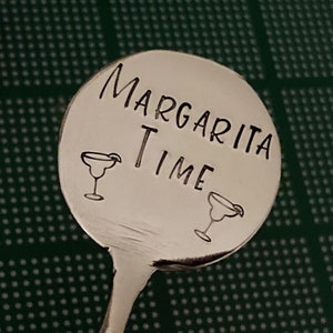 Peut inclure: Un m&eacute;langeur &agrave; margarita en argent avec une t&ecirc;te ronde grav&eacute;e qui dit "Margarita Time" avec deux ic&ocirc;nes de verre &agrave; margarita.