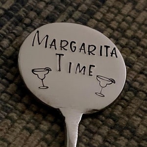 Peut inclure: Un agitateur &agrave; margarita en m&eacute;tal argent&eacute; avec un dessus rond qui dit "Margarita Time" avec deux illustrations de verres &agrave; margarita.