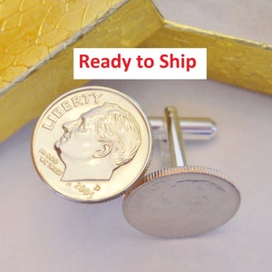 May include: Silver cufflinks featuring a 2005 United States dime coin on each side. The coin features the profile of Franklin D. Roosevelt and the inscription "LIBERTY" and "IN GOD WE TRUST".