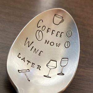 May include: Silver spoon with the text "Coffee Now Wine Later" engraved on it. The spoon also has a coffee cup, coffee beans, wine glasses, and a corkscrew engraved on it.