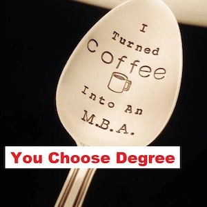 May include: A silver spoon with the text "I Turned Coffee Into An M.B.A. You Choose Degree" engraved on it. The spoon features a small coffee cup icon.