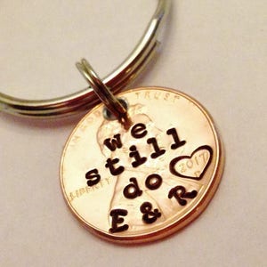 May include: A copper penny keychain with the words "We still do E & R" and a heart with the year 2017 engraved on it.