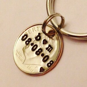 May include: Silver key chain with a US quarter coin attached. The coin has the date 08-08-08 engraved on it with two small hearts.