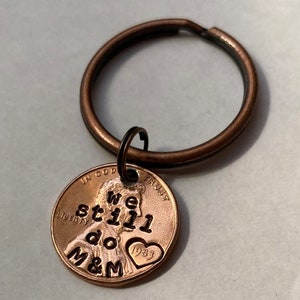 May include: A copper penny keychain with the words "We still do M&M" engraved on it. The penny has a heart with the year 1983 on it.