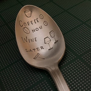 May include: A silver spoon with the text "Coffee Now Wine Later" engraved on it. The spoon also has a small coffee cup, coffee bean, and wine glass illustrations.