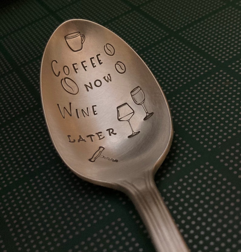 May include: A silver spoon with the text "Coffee Now Wine Later" engraved on it. The spoon also has a small coffee cup, coffee bean, and wine glass illustrations.