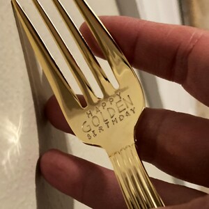 May include: A gold-colored fork with the words "Happy Golden Birthday" engraved on the handle.