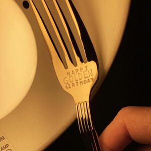 May include: A gold fork with the words "Happy Golden Birthday" engraved on the handle.